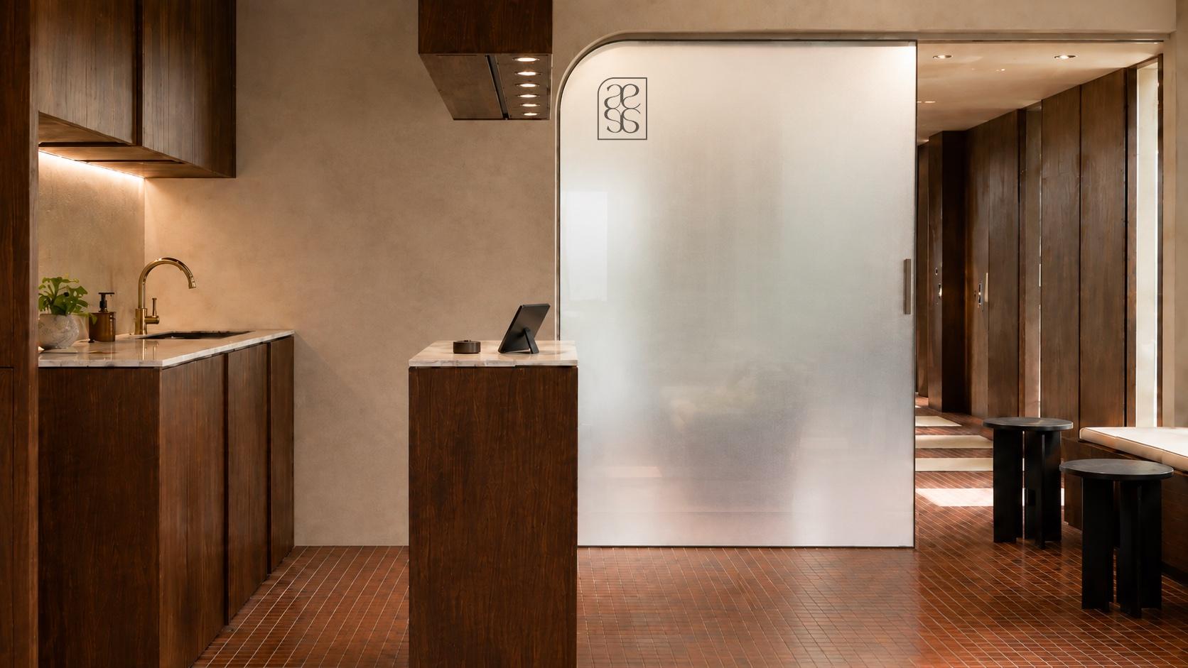 Détail du studio Almae, pierre travertin, bois clair et linge plié